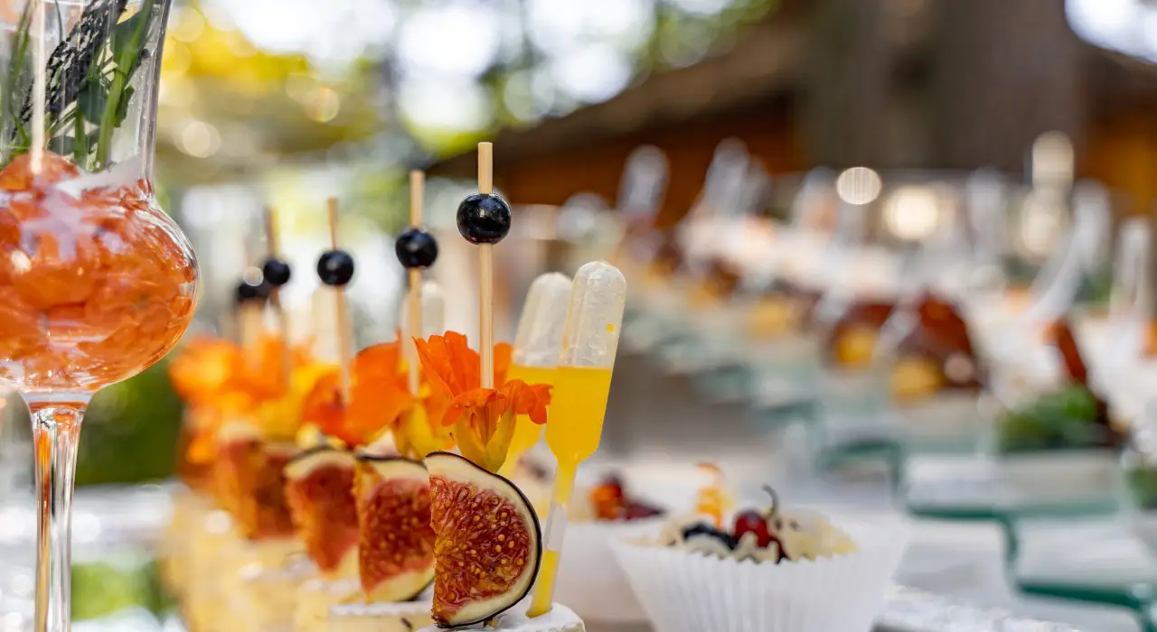 籌款活動上的精緻開胃小食特寫，配有水果和鮮花裝飾。