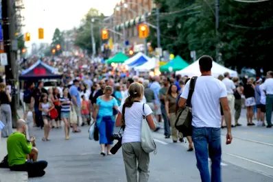 Crowd of people walking through a busy outdoor street festival