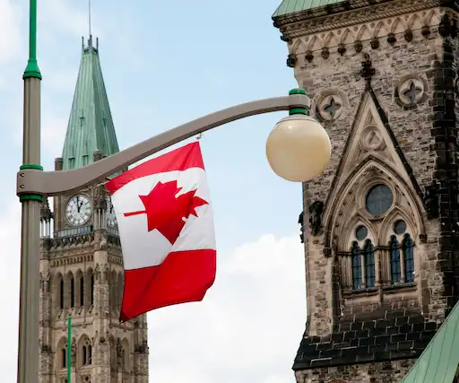 Canadian flag waving in front of the Parliament buildings in Ottawa, Canada.
